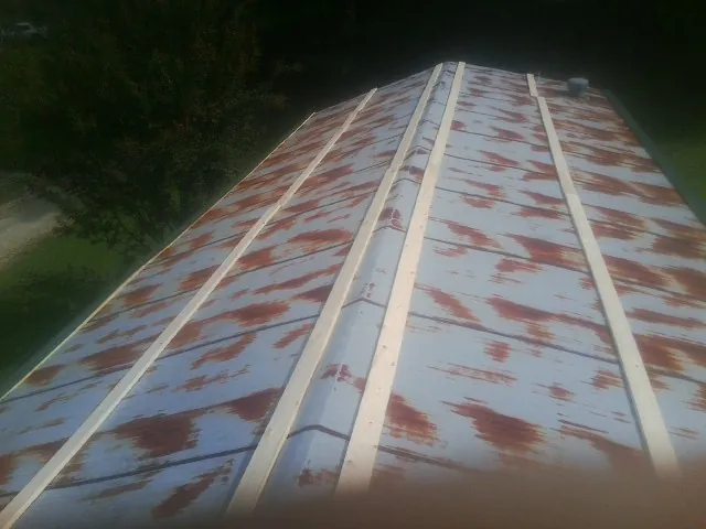 Rusted metal roof panels with new wood purlins before replacement — Storm Damage Roof Repair in Canton Center by Roofing Brothers