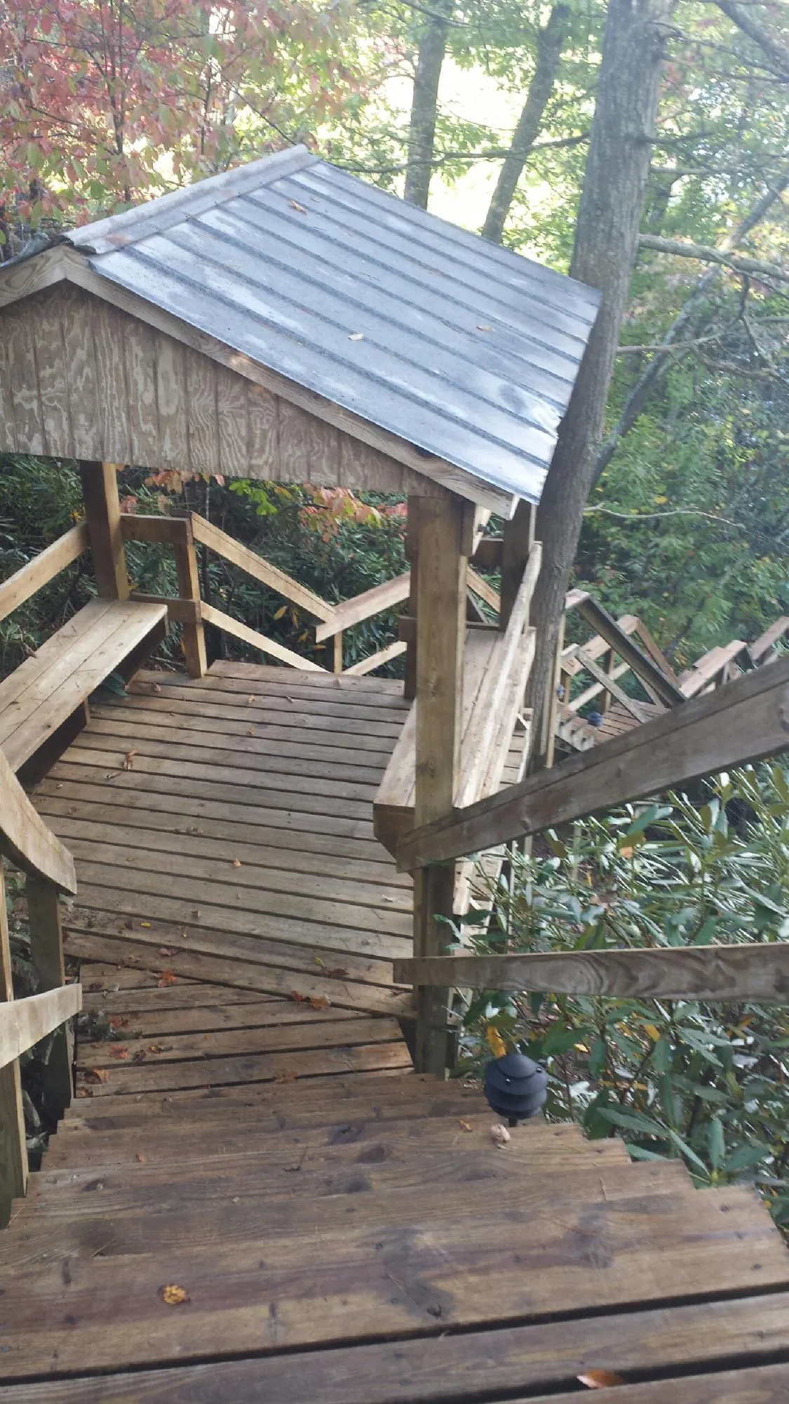 Metal roofed shelter over wooden steps on a wooded walkway — Skylight Repair & Installation work by our crew in Canton Center