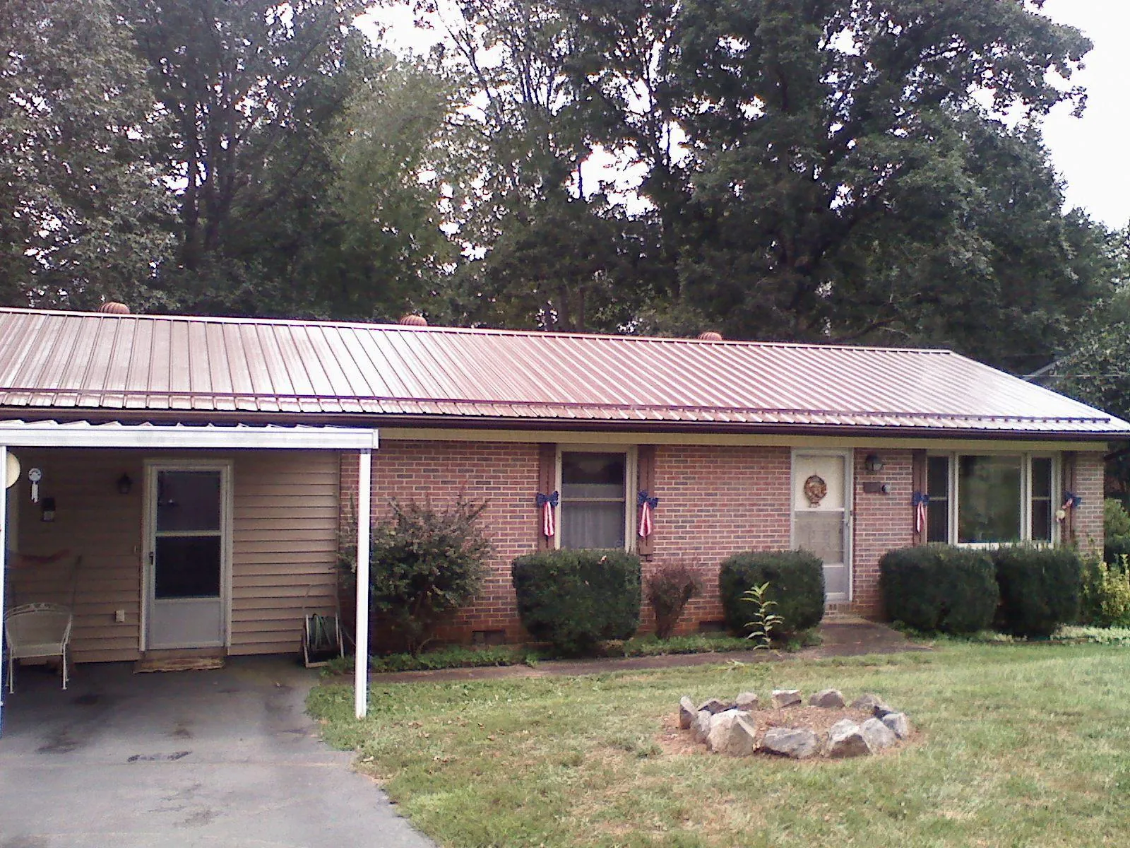 Bronze metal roof and carport on a brick ranch home — Roof Repair work by our crew in Canton Center